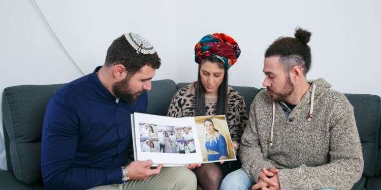 האחים לבית מונסנגו. אחיה, תהילה ומאור. במרכז, תמונותיה של הודיה. צילום: לירון מולדובן "אחותנו חצי שנה בכלא בפרו, למה אותנו לא שומעים?"