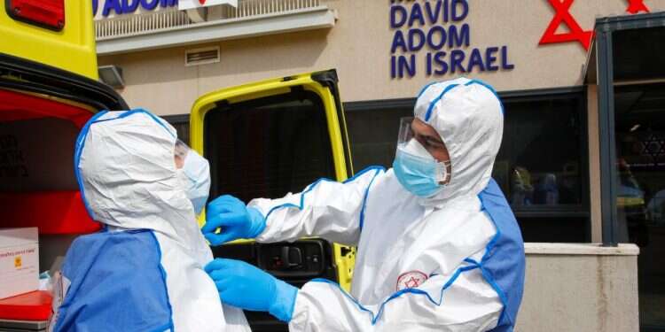 פרמדיקים בלבוש מגן, כחלק מתרגול טיפול בחולה קורונה. צילום: AFP בהלת הקורונה: הזכות לפרטיות או בריאות הציבור?