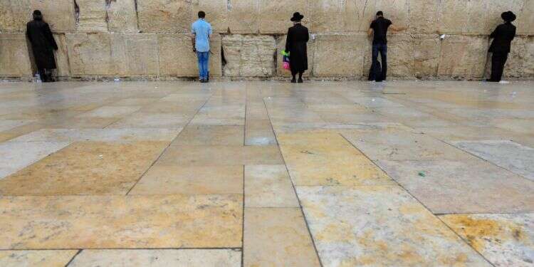 רחבת הכותל, אתמול. הרבנים ביקשו להימנע מתפילה המונית גם תחת כיפת השמיים צילום: איי.אף.פי פיצול מניינים וגל שקט ברדיו: רבנים התארגנו לשבת בצל הקורונה