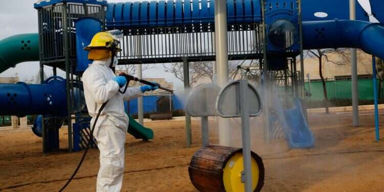 חיטוי גינת משחקים במודיעין. צילום: AFP במגפת ענק, המטרה היא להקטין את מספר הטעויות