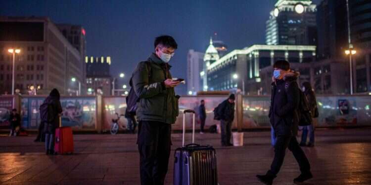 צעיר סיני בתחנת הרכבת בבייג'ינג. צילום: AFP