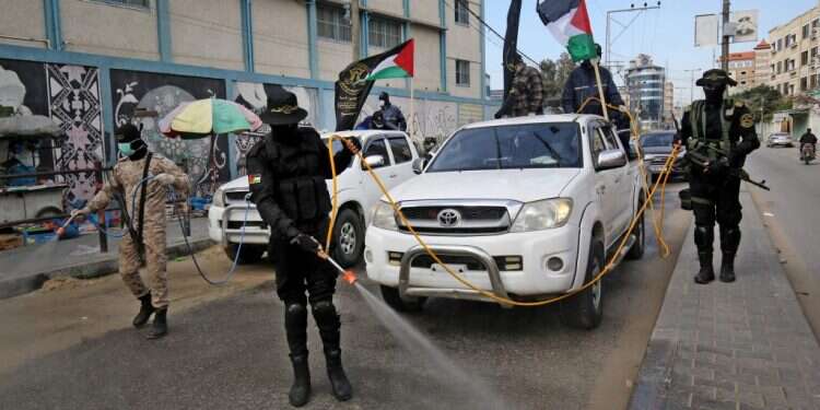 חברי הג'יהאד האסלאמי הפלסטיני מחטאים רחוב בעזה. צילום: AFP "לא נמות לבד": בעזה מנסים לקבל סיוע באיומים