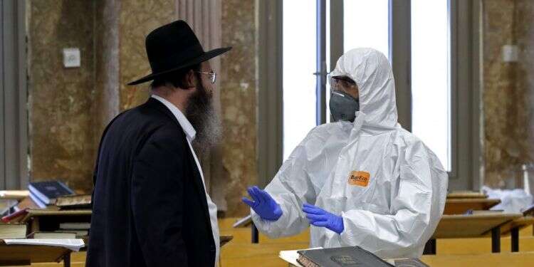 שוטר משוחח עם אדם חרדי בבני ברק. צילום: AFP אם נושיט לחרדים יד כעת – הם יצטרפו אלינו