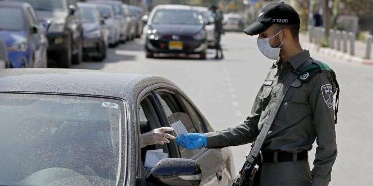 נקודת בדיקה משטרתית באזור בני ברק. צילום: AFP שו"ת עוצר: מה מותר ומה אסור במסגרת תקנות החירום
