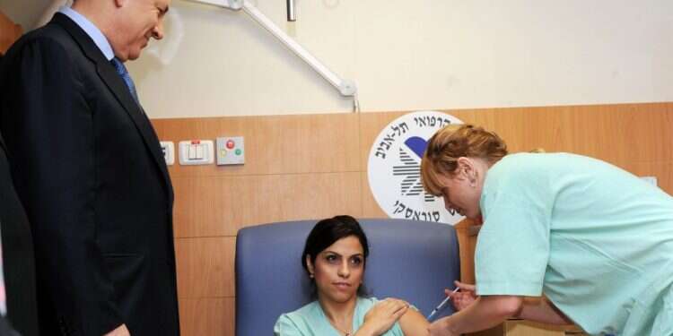 חיסון נגד שפעת החזירים ב־ 2009 במעמד נתניהו. קשוב לביקורת. צילום: עמוס בן־גרשום, לע למרות ההמלצות: אין לישראל מפעל חיסונים משל עצמה