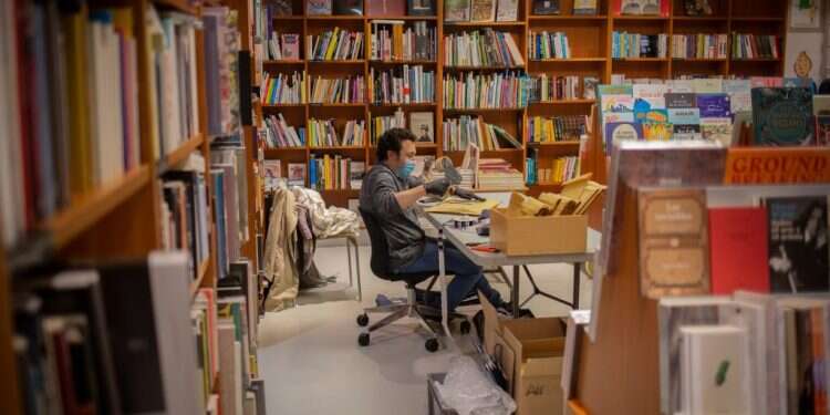 עובד בחנות ספרים בברצלונה, ספרד. צילום: גטי אימג'ס הפנדמיה של עולם הספרים