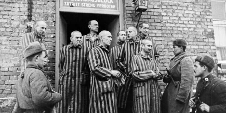 חיילי הצבא האדום עם אסירי אושוויץ, 1945. צילום: גטי אימג'ס שמחה ונקמה: מכתבים מ"פלנטה אחרת" אחרי השחרור