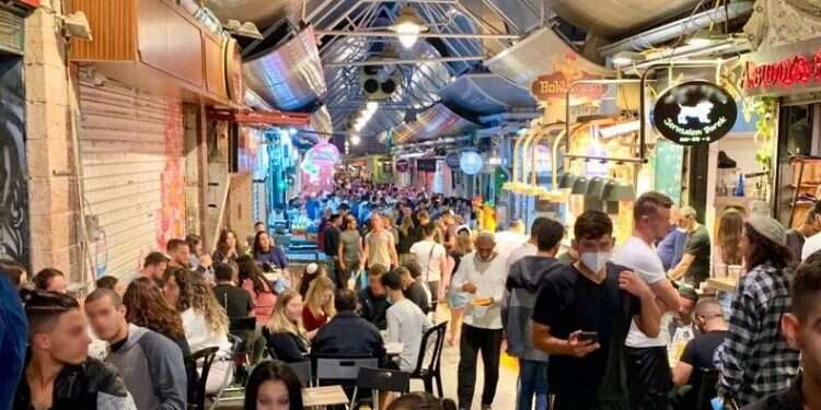 שוק מחנה יהודה בירושלים בסוף השבוע האחרון. למצולמים אין קשר לכתבה. צילום: חני ג'ינה כהן דווקא כשהסיכון גדול מתמיד – התרגלנו לקורונה