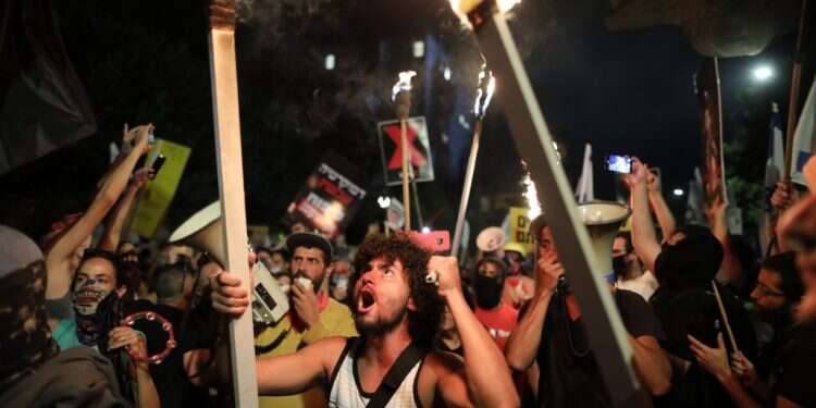 הפגנה נגד השחיתות מול בית ראש הממשלה בירושלים, השבוע. צילום: EPA הכתובת שהייתה על הדף עברה אל הקיר ברחוב בלפור