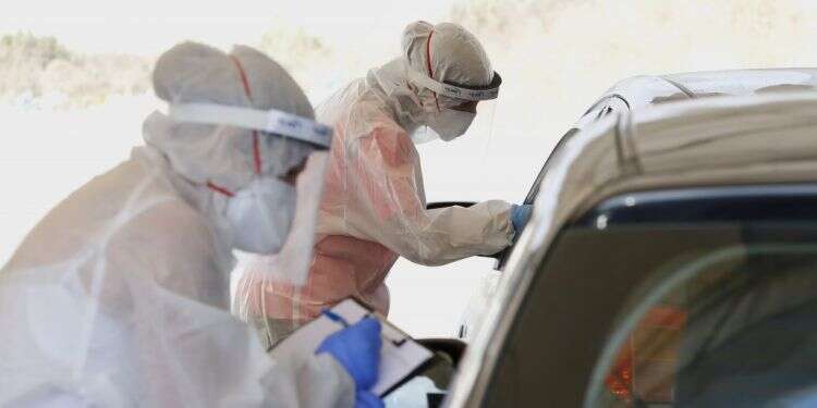 בדיקות קורונה במתחם דרייב אין. צילום: AFP חישוב מסלול מחדש: צמצום מערך בדיקות הקורונה