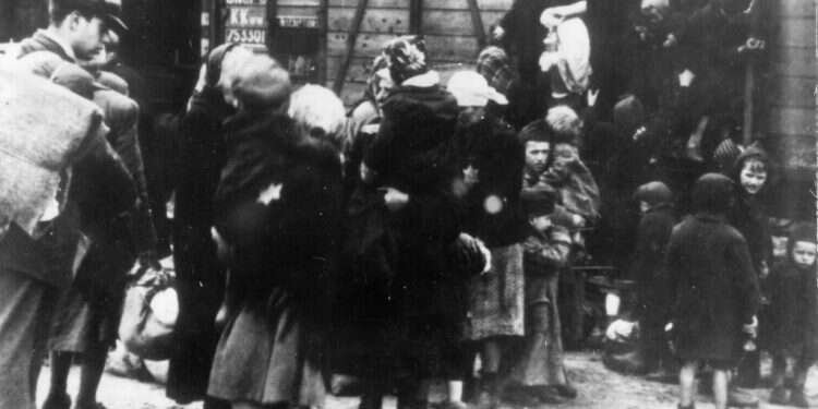 יהודים יורדים מהרכבות אל מחנה אושוויץ. צילום: גטי אימג'ס הלוחם הפולני שהתנדב לרגל באושוויץ