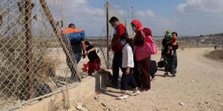 פלסטינים חוצים את הפירצה בגדר בדרך לים. צילום: EPA בצה"ל מעלימים עין מאלפי פלסטינים שחודרים לישראל