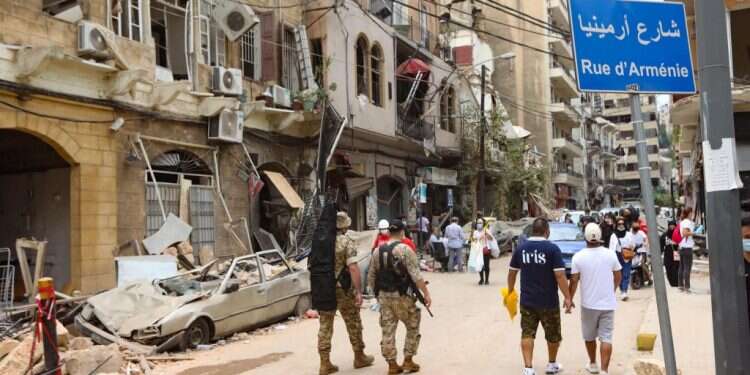 תושבים וחיילים בוחנים את ההרס באחד הרחובות במרכז ביירות, אתמול צילום: איי.אף.פי עמנואל מקרון בסיור בביירות: "בלי רפורמות, לבנון תסבול"