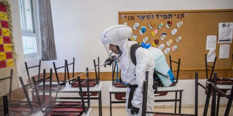 חיטוי בית ספר בירושלים. צילום: יונתן זינדל, פלאש 90 ליקויים, ניתוק ומסרים סותרים: הכאוס במערכת החינוך חוגג