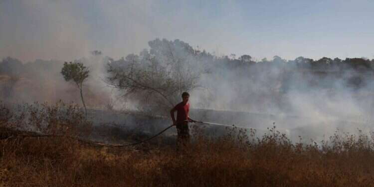 כבאי מכבה דלקה בעקבות נפילת בלון תבערה ששוגר מעזה // אוגוסט 2020 , אב תש צילום: AFP