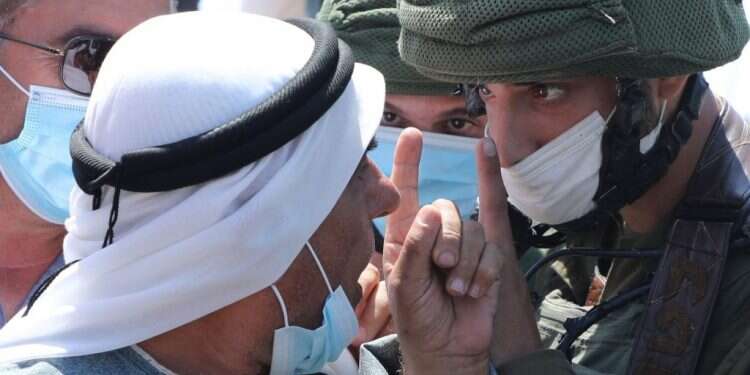 פלסטיני מתווכח עם חיילי צה צילום: AFP