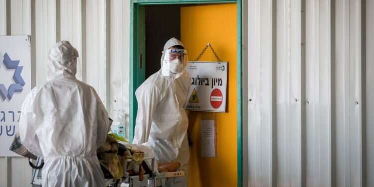 להחליט בתוך דקות במי לטפל. סניטרים מובילים חולה לחדר מיון קורונה בבית החולים שערי צדק. צילום: נתי שוחט, פלאש 90