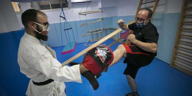 צביקה עם מאמן אומנויות הלחימה דויד ליבנשטיין. צילום: אוליבייה פיטוסי, פלאש 90