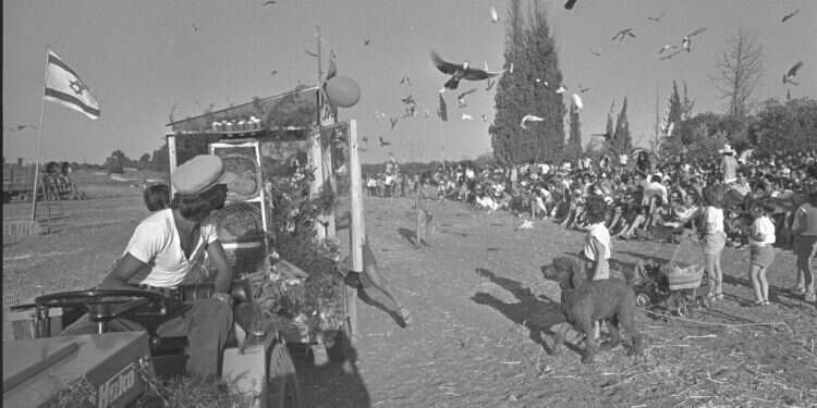 לבני הקיבוצים הייתה תחושת שייכות טבעית וקשר עמוק עם יהדותם. ילדי קיבוץ גבעת ברנר משחררים יונים במהלך חגיגות חג השבועות, 1973. צילום: חנניה הרמ, לע כיפה אדומה בדגניה: אוטוביוגרפיה של היסטוריה יהודית