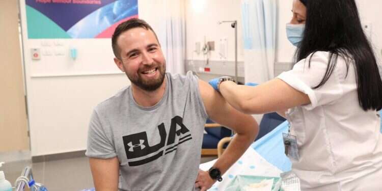 הנסיין הראשון שגב הראל לחיסון לקורונה בבית החולים שיבא תל השומר. צילום: אגף דוברות והסברה, משרד הביטחון החיסון הישראלי לקורונה: החל שלב הניסוי בבני אדם