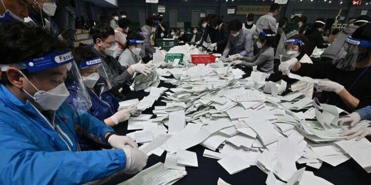 ספירת קולות בקוריאה הדרומית, בחודש אפריל. צילום: גטי אימג'ס הצבעה בימי קורונה: כך בחרו בעולם בעת המגפה