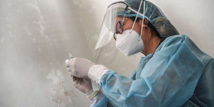 אחות מתכוננת לחסן נגד קורונה. צילום: AFP הַצָּלָה וְתַבְהֵלָה