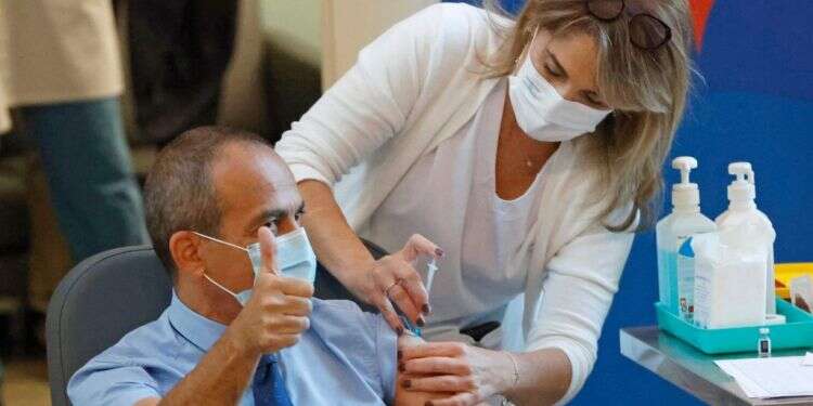 פרופ' רוני גמזו מתחסן נגד קורונה. צילום: AFP התורים, המרכזים והלו"ז: כיצד ומתי תתחסנו נגד קורונה