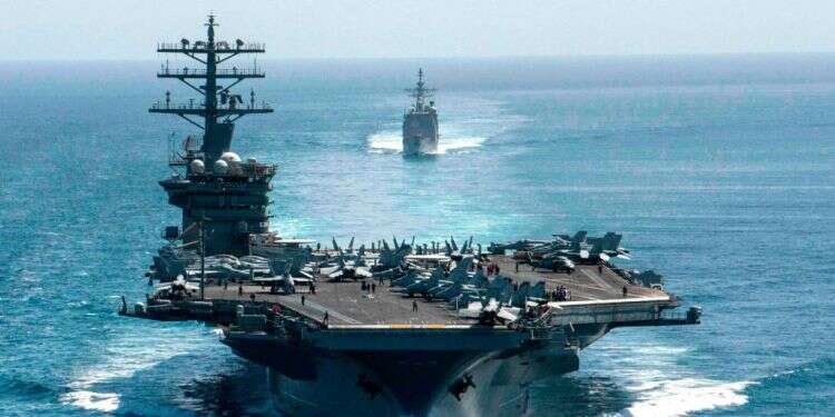 נושאת מטוסים אמריקנית במצרי הורמוז. צילום: AFP מה עומד מאחורי הופעת צוללות ומטוסים במפרץ הפרסי?