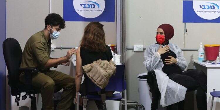 מתחסנים בקופת חולים מכבי. צילום: EPA נתונים ראשונים: רמת יעילות מדהימה בחיסוני פייזר