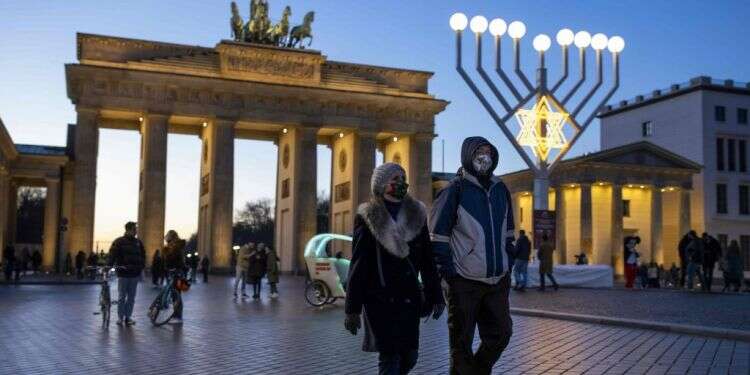 מטיילים ליד שער ברנדנבורג בחג החנוכה, ברלין, 19 בדצמבר 2020. צילום: AFP