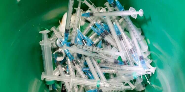 מזרקי חיסונים לאחר השימוש. צילום: AFP מומחים מסבירים: למה גם מחוסנים צריכים לעטות מסכות, בינתיים