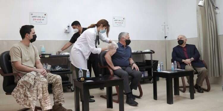 עבדאללה (במרכז), בנו חוסיין ודודו חסן מתחסנים לקורונה. צילום: EPA