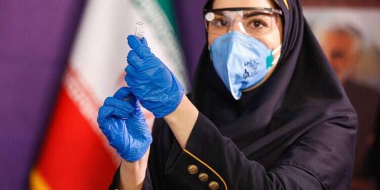 עובדת בריאות מכינה את החיסון המקומי בעיר טהרן שבאיראן. צילום: AFP טאיוואן, אוקראינה ואיראן מסרבות לקבל חיסונים ממדינות עוינות