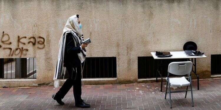 תפילה במגרש חנייה בבני ברק, ינואר 2021. צילום: AFP "הזן החרדי" יישאר כאן גם כשהזן הבריטי יצא מחיינו