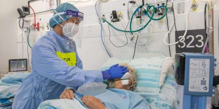 אחות במחלקת קורונה תומכת במאושפזת. צילום: יוסי אלוני