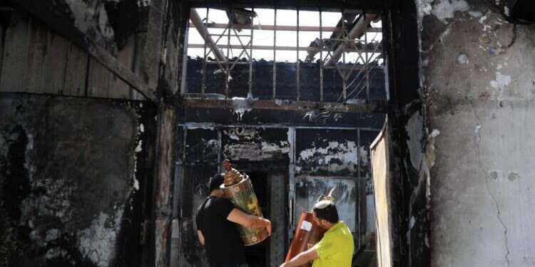 ספרי תורה מוצאים מבית כנסת שרוף בלוד. צילום: אי.פי.איי "אנחנו רוצים משילות": מאיר ליוש הפך לקולם של תושבי לוד היהודים