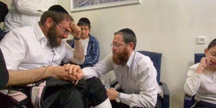 הרב אביגדור חיות (משמאל) מנחם את דוד, אביו של משה ז