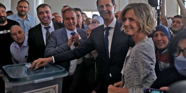 נשיא סוריה בשאר אל אסד מלווה באשתו אסמא מצביע קלפי בעיר דומא שבפרברי דמשק. צילום:AFP בחירות בסוריה: אסד חוזר לחיקה של הקהילה הבינלאומית