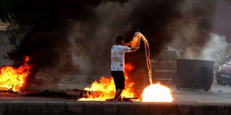 מפגין נגד הממשל בלבנון מוסיף שמן למדורת המחאה. צילום: EPA בישראל מעריכים: המשבר הכלכלי בלבנון מאיים על קיומו של חיזבאללה