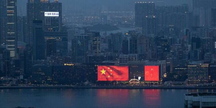 דגל סין מתנוסס על מבנה בהונג-קונג. צילום: EPA שנה ל"חוק הביטחון" בהונג-קונג: השתקה, הטרדה והפרת זכויות אדם