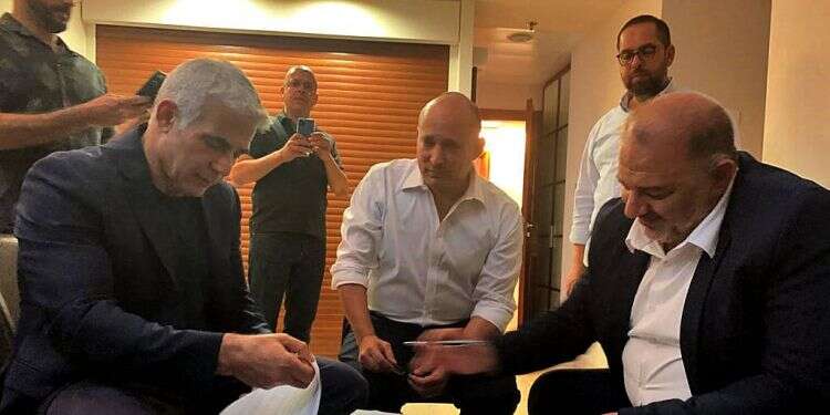 עבאס, בנט ולפיד בחתימה על ההסכמים הקואליציוניים. צילום: AFP הצטרפות רע"ם לגוש בנט-לפיד: רעידת אדמה בפוליטיקה הערבית