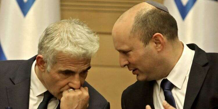 ראש הממשלה נפתלי בנט ושר החוץ יאיר לפיד. צילום: AFP חוק איחוד משפחות והצעות אי־אמון: האתגרים והמלכודות של הממשלה