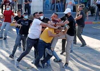 אנשי ביטחון פלסטינים בלבוש אזרחי תוקפים מפגין ברמאללה בסוף השבוע שעבר. צילום: AFP