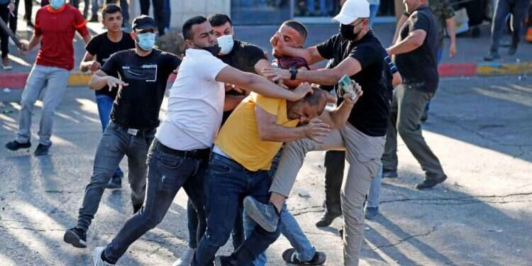 אנשי ביטחון פלסטינים בלבוש אזרחי תוקפים מפגין ברמאללה בסוף השבוע שעבר. צילום: AFP