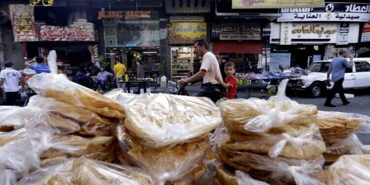 דוכן לחם בשוק בדמשק. צילום: AFP לא רק לבנון: סוריה מעלה את מחירי הלחם והדלק