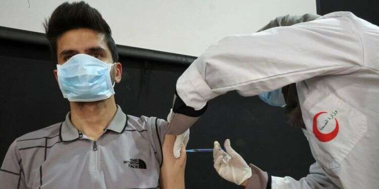 צעיר מתחסן בעיירה דורא בהר חברון, אוגוסט 2021. צילום: AFP שרת הבריאות הפלסטינית: תפסיקו להתחבק ולהתנשק