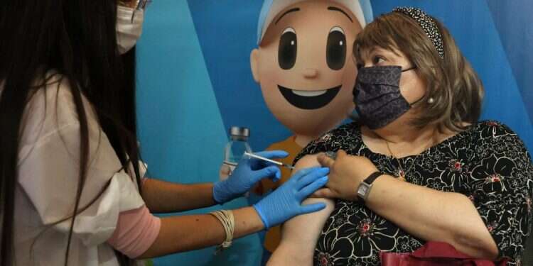 מתחסנת בשלישית בירושלים. צילום: AFP מנת החיסון השלישית הכפילה את מספר המחוסנים בקרב מושתלי האיברים