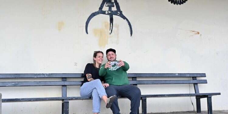 סלפי על רקע גרפיטי של בנקסי. AFP