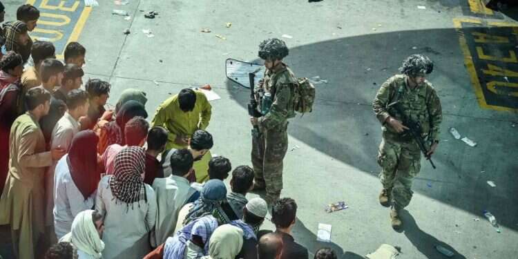 חיילים אמריקנים
מול אזרחים
אפגנים בשדה התעופה בקאבול, השבוע. צילום: AFP השד האפגני יצא מהבקבוק, והוא מאיים לערער את התמיכה בנשיא ארה"ב