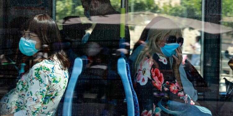 נוסעות עוטות מסכה באוטובוס ירושלמי. צילום: AFP מתקרבים לשיא שלילי: 9,831 נדבקים בקורונה ביממה האחרונה